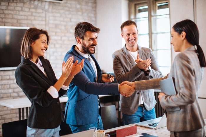 people in office shaking hands